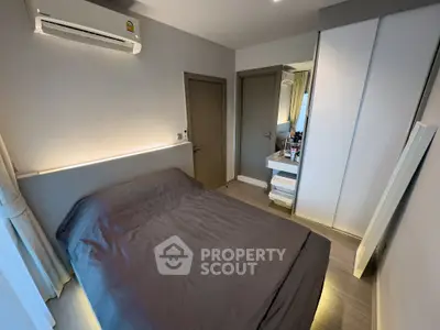 Modern bedroom with sleek design and built-in wardrobe, featuring ambient lighting and air conditioning.
