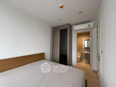 Modern bedroom with ensuite bathroom and wooden furniture