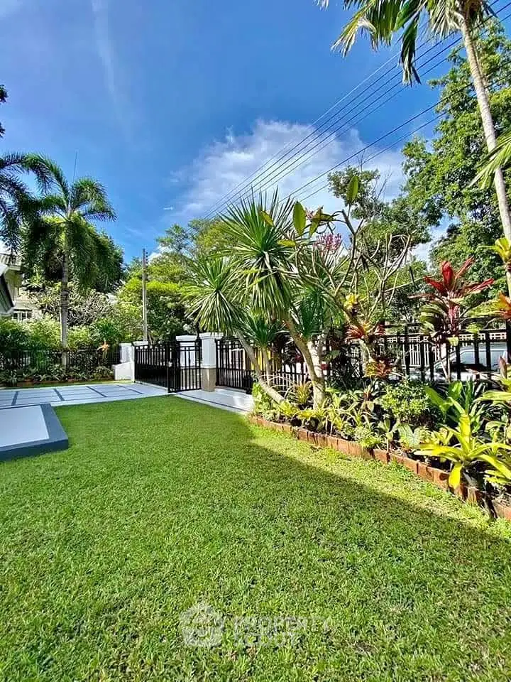 Beautiful garden view with lush greenery and modern fencing in a serene residential area.
