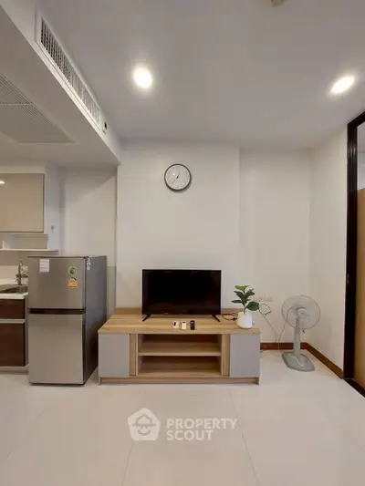 Modern living room with sleek TV stand and stainless steel fridge