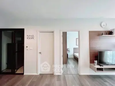 Modern apartment interior with sleek design and wooden flooring, featuring a cozy bedroom and stylish living area.