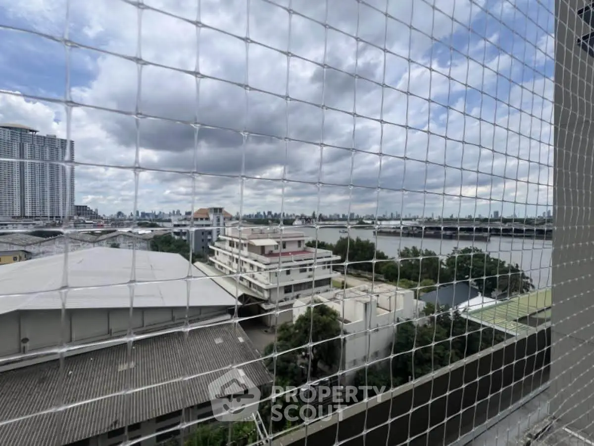 Stunning cityscape view from a high-rise balcony with river and skyline in the background.