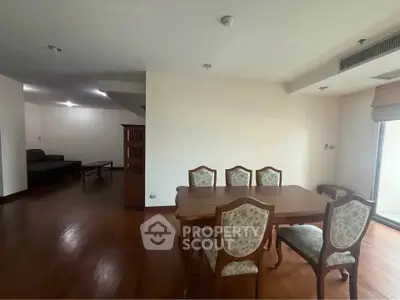 Spacious dining area with elegant wooden furniture and open layout in modern apartment.