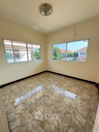 Bright empty room with large windows and glossy tiled floor