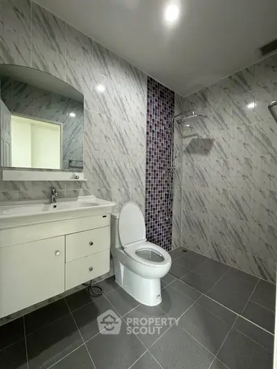 Modern bathroom with sleek tiles and spacious shower area