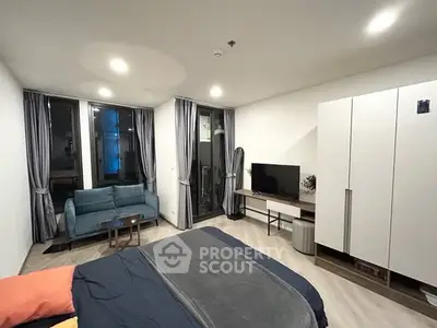 Modern bedroom with cozy seating area and large windows for natural light.