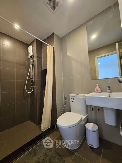 Modern bathroom with sleek shower and contemporary fixtures in stylish apartment.