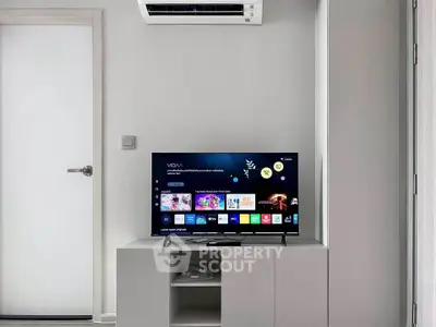 Modern living room with sleek TV setup and air conditioning unit.