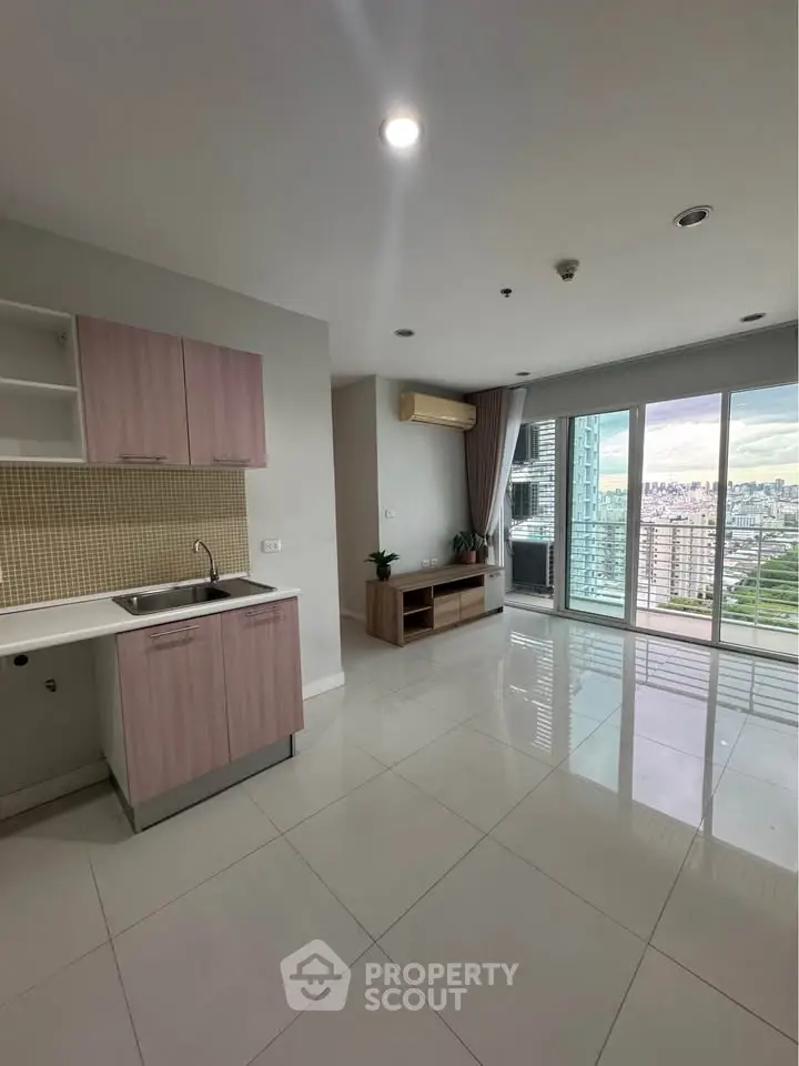 Modern open-plan living room with kitchen and stunning city view balcony.