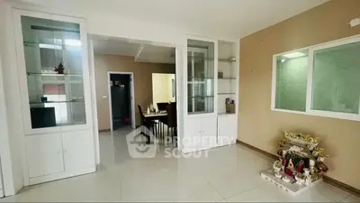 Spacious living area with built-in cabinets and dining room view, perfect for modern family living.