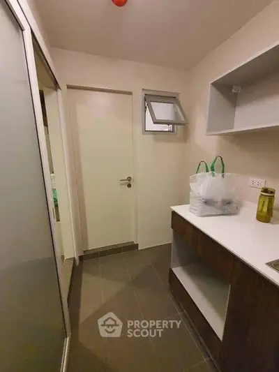 Compact utility room with storage shelves and countertop in modern apartment.