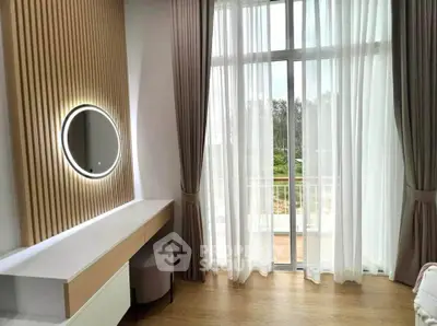 Elegant bedroom with modern vanity and large window overlooking balcony