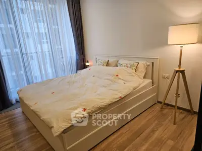 Cozy bedroom with modern decor and natural light in a stylish apartment.