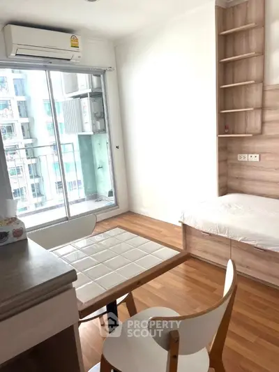 Modern studio apartment with wooden flooring and balcony view