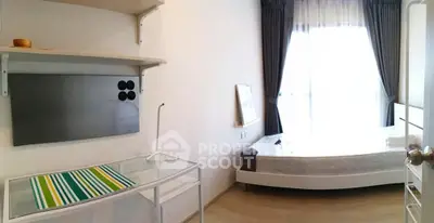 Bright and airy bedroom with modern furnishings and large window for natural light.