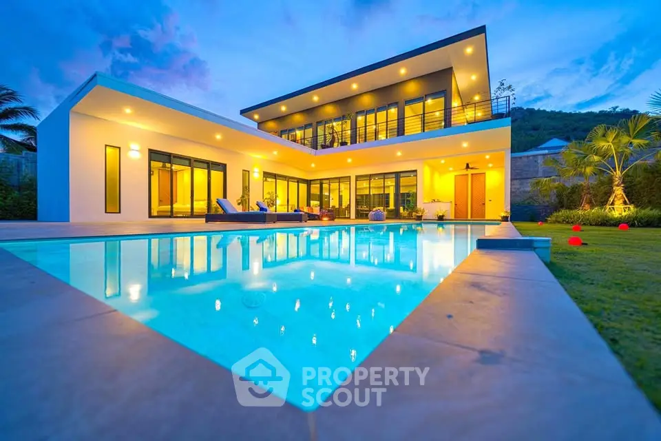 Luxurious modern villa with stunning pool and elegant lighting at dusk, perfect for upscale living.