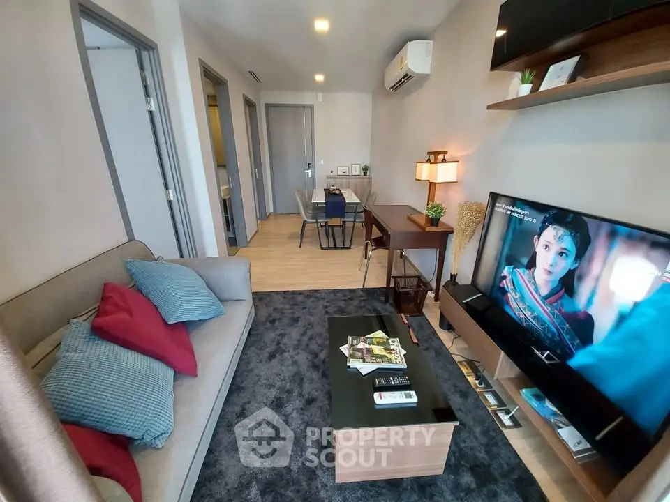 Modern living room with cozy sofa, TV, and stylish decor in a contemporary apartment.