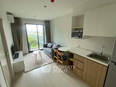 Modern living room with open kitchen and balcony view in a stylish apartment.