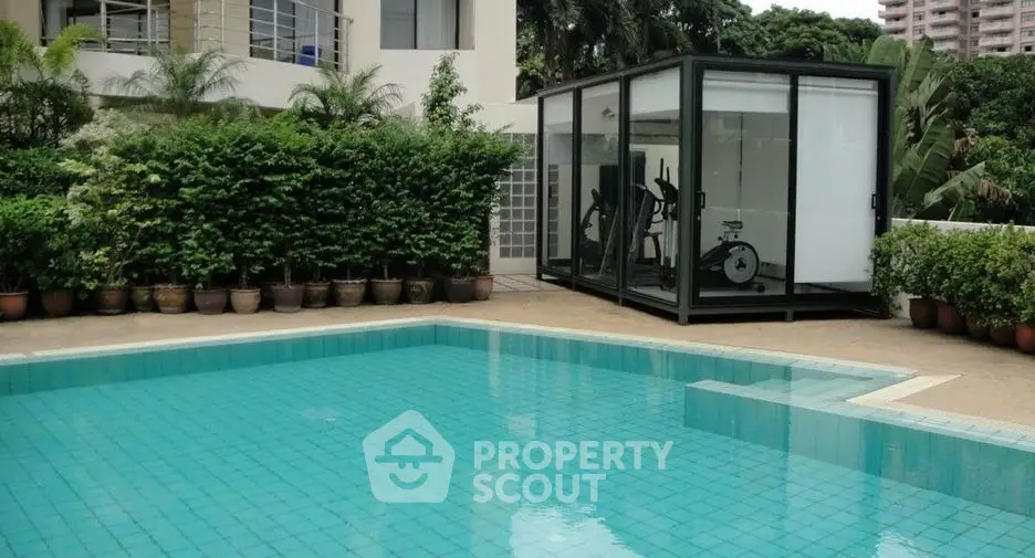 Luxurious outdoor pool with modern gym room in lush garden setting