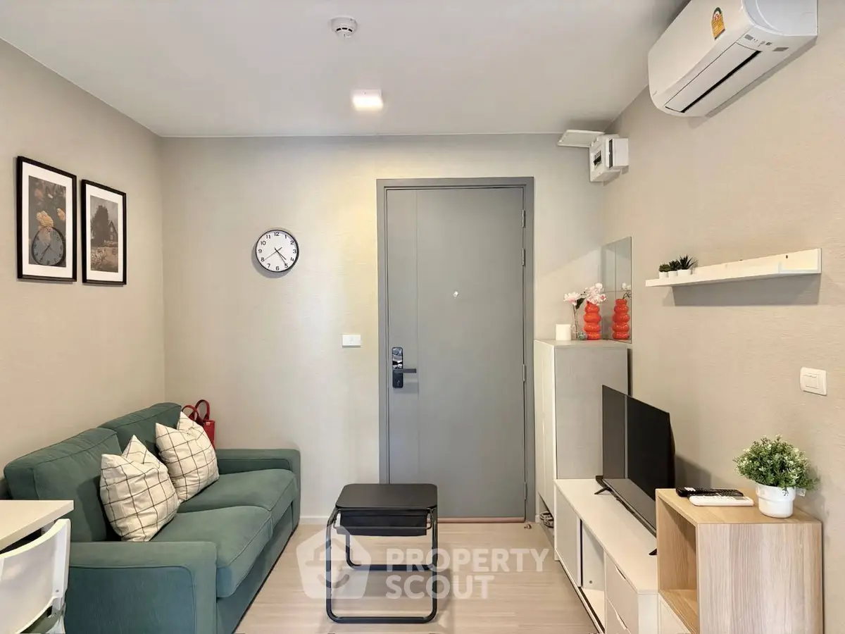 Modern living room with stylish decor, featuring a cozy sofa, wall-mounted TV, and air conditioning.
