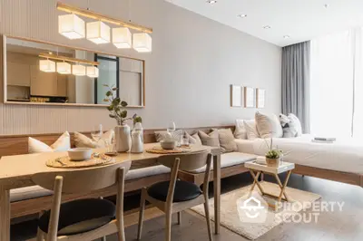 Modern open-plan living room with dining area and cozy bedroom in stylish apartment.