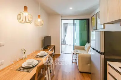 Modern open-plan living room with dining area and stylish lighting in a cozy apartment.