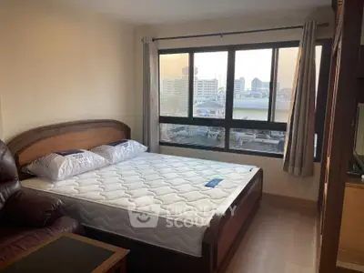 Cozy bedroom with large window offering stunning city views, featuring a comfortable bed and elegant furnishings.
