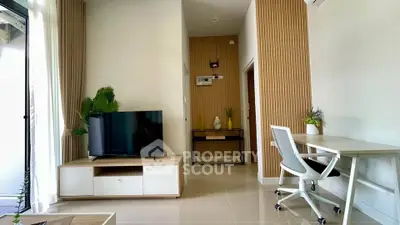 Modern living room with TV, desk, and stylish decor in a bright apartment.