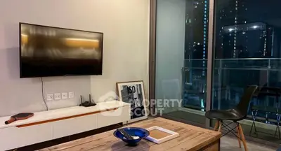 Modern living room with wall-mounted TV and balcony view in urban apartment