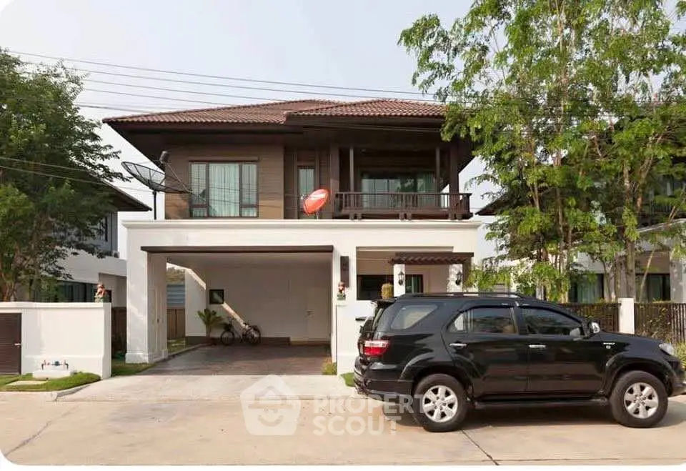 Charming two-story house with balcony and driveway in a serene neighborhood.