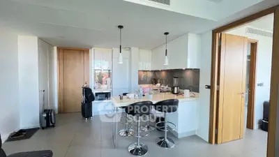 Modern kitchen with sleek design and breakfast bar in open layout apartment.