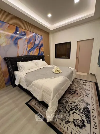 Luxurious bedroom with elegant decor and plush bedding in modern apartment.