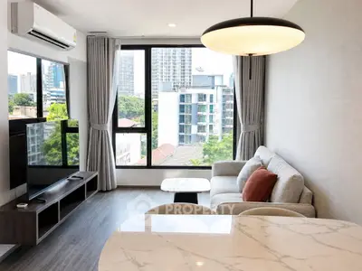 Modern living room with city view, featuring stylish furniture and large windows for natural light.