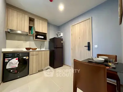 Modern kitchen with wooden cabinets, washing machine, and dining area in cozy apartment.