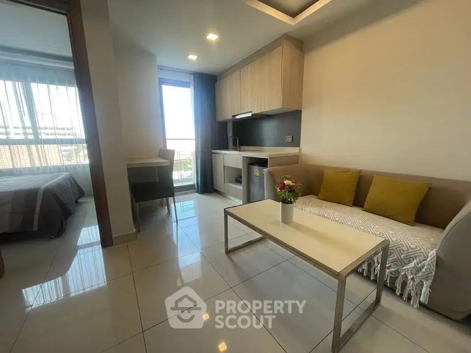 Modern living room with cozy sofa, sleek coffee table, and open kitchen in stylish apartment.
