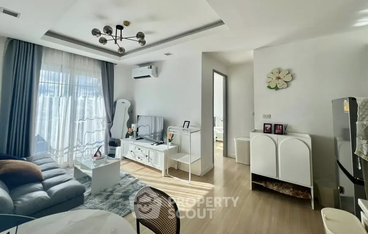 Modern living room with stylish decor and natural light, featuring a cozy sofa and sleek furniture.