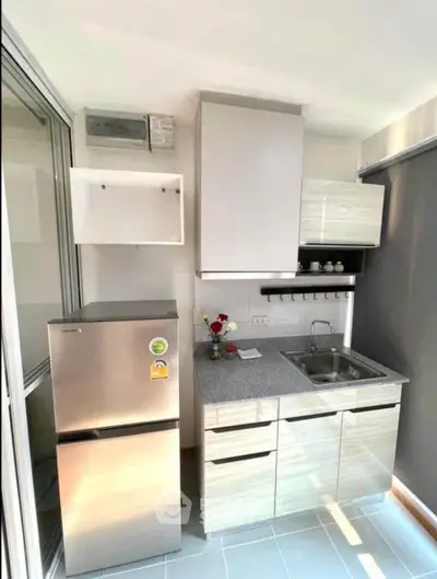 Modern compact kitchen with sleek cabinets and stainless steel fridge