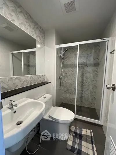 Modern bathroom with sleek shower and stylish tiles in contemporary apartment.