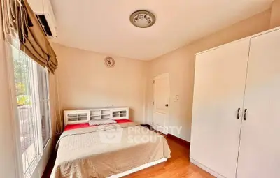 Cozy bedroom with natural light and wooden flooring