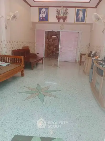 Spacious living room with unique flooring and traditional decor, perfect for family gatherings.