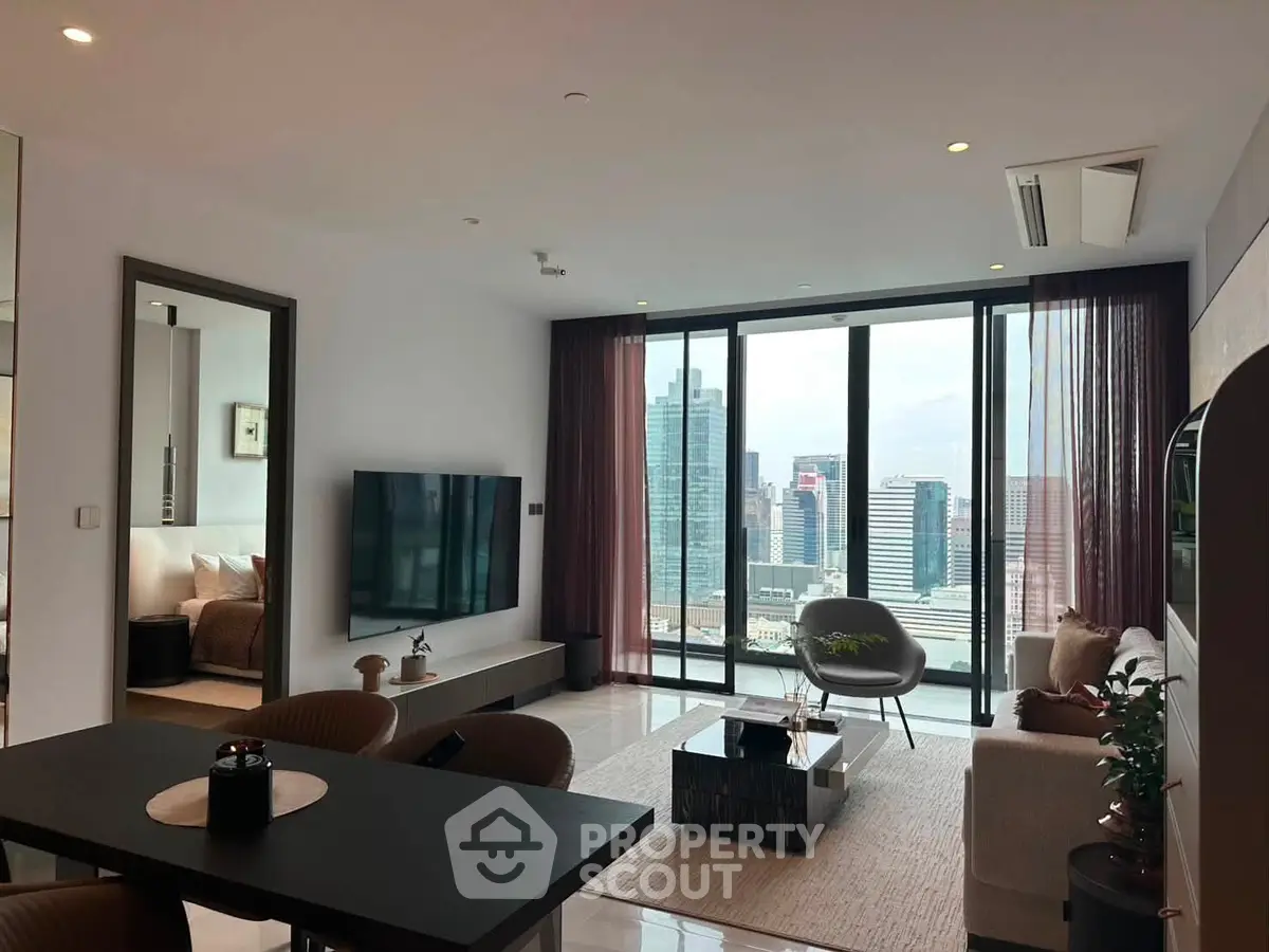 Modern living room with city view, sleek furniture, and large windows in a high-rise apartment.