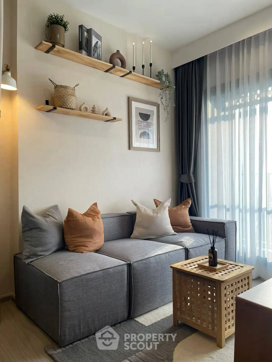 Stylish modern living room with cozy gray sofa, wooden accents, and natural light.