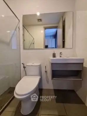 Modern bathroom with sleek fixtures and glass shower enclosure.