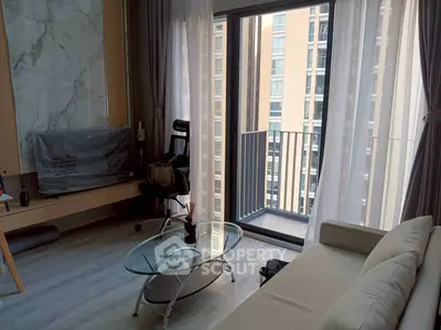 Modern living room with floor-to-ceiling windows and small balcony in urban apartment.