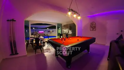 Luxurious home interior with pool table and modern kitchen, perfect for entertainment and relaxation.