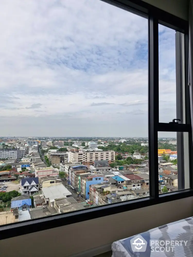 Stunning cityscape view from high-rise apartment window showcasing urban living.