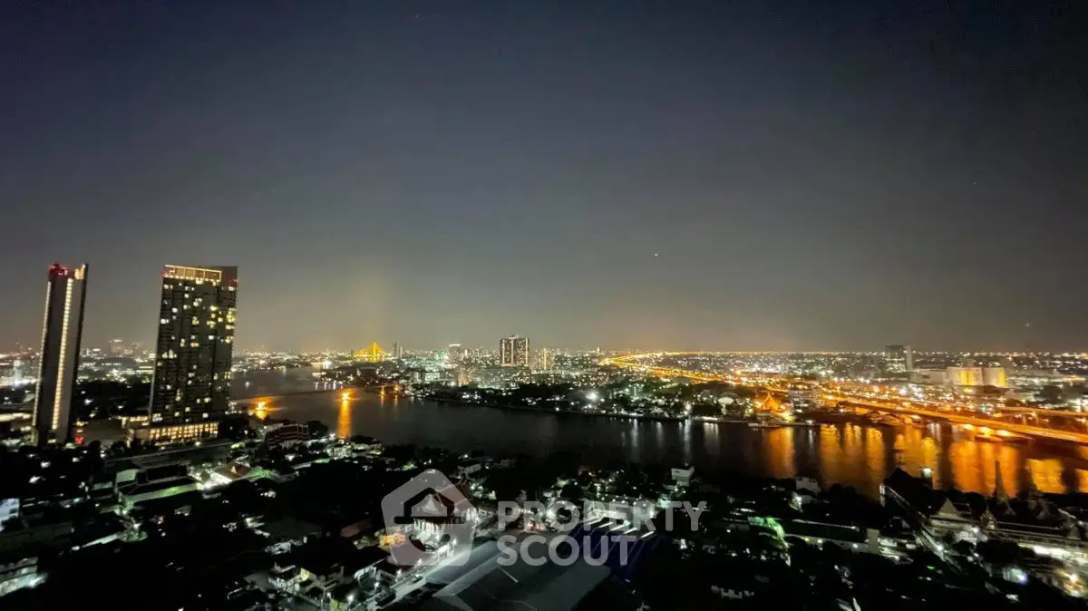 Stunning night view of city skyline and river from high-rise apartment balcony.
