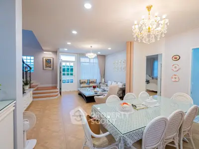 Spacious and elegant living room with dining area, featuring chandeliers and stylish decor.
