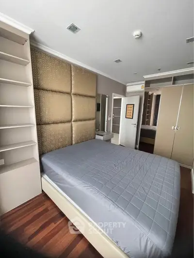 Spacious bedroom with modern design and ample storage in a luxury apartment.