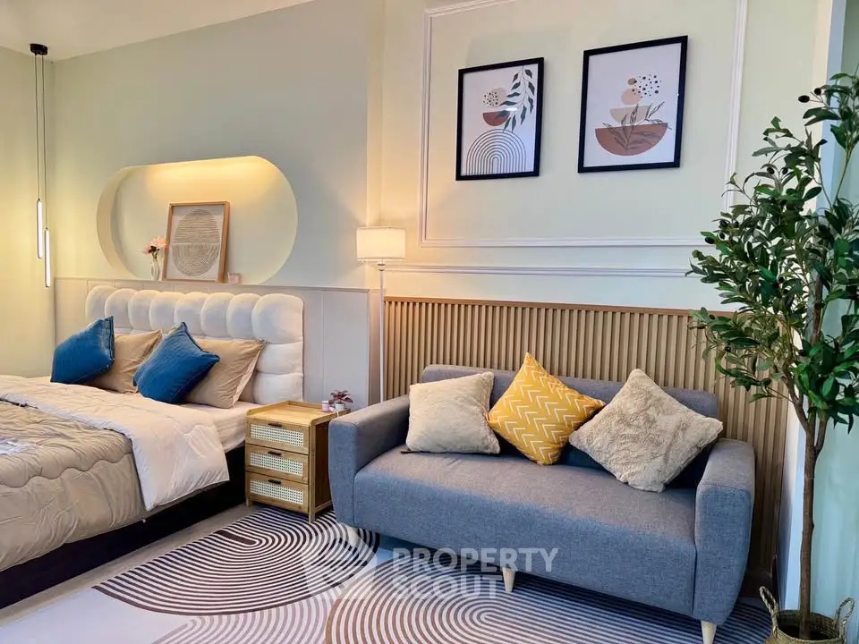 Stylish bedroom with modern decor, cozy sofa, and elegant wall art for a serene living space.